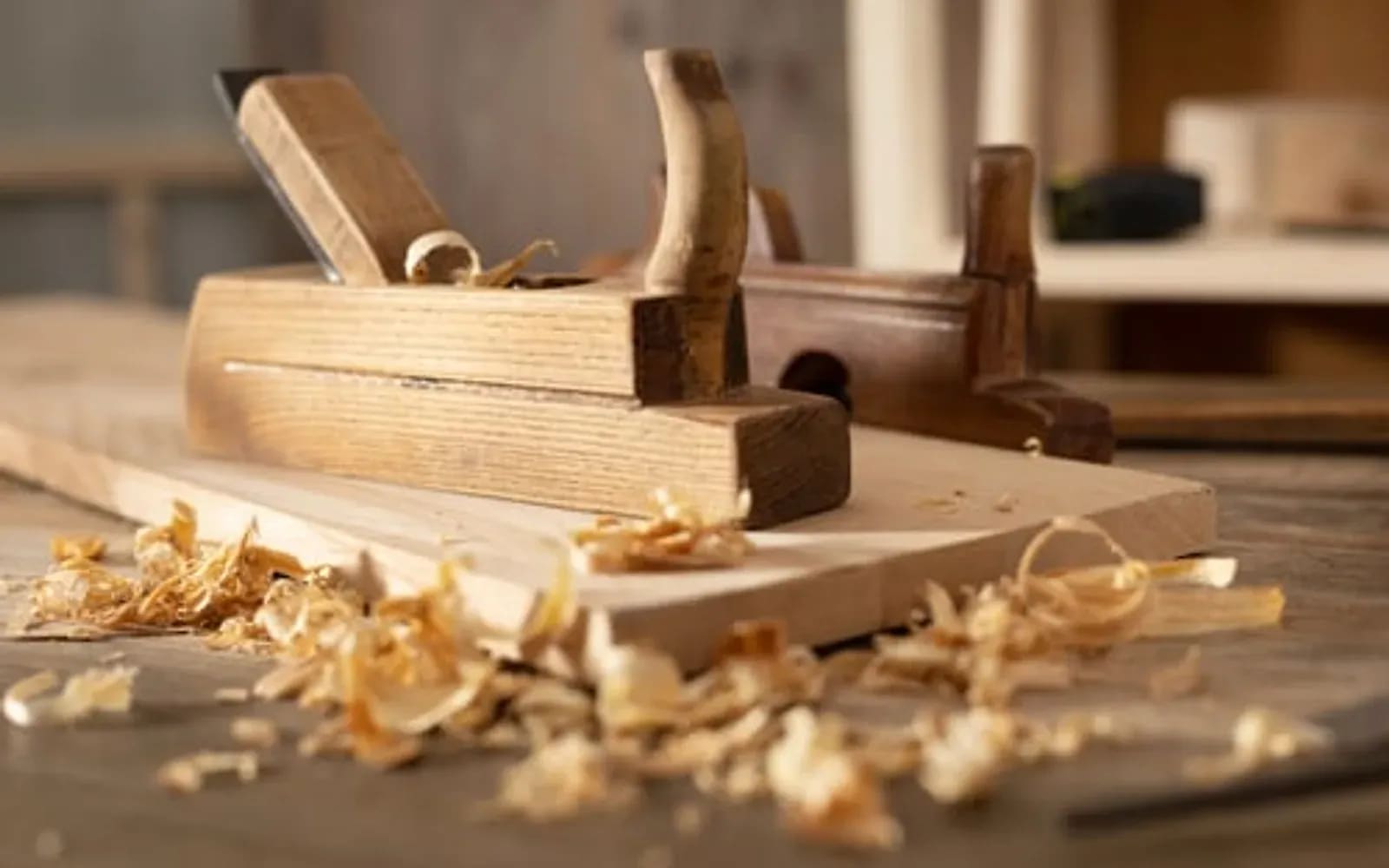 Hand plane and wood shavings on a carpenter's workbench during finish carpentry work