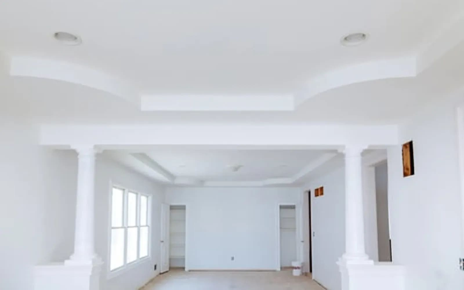 Formal room with tray ceiling, crown molding and column detail in a luxury home